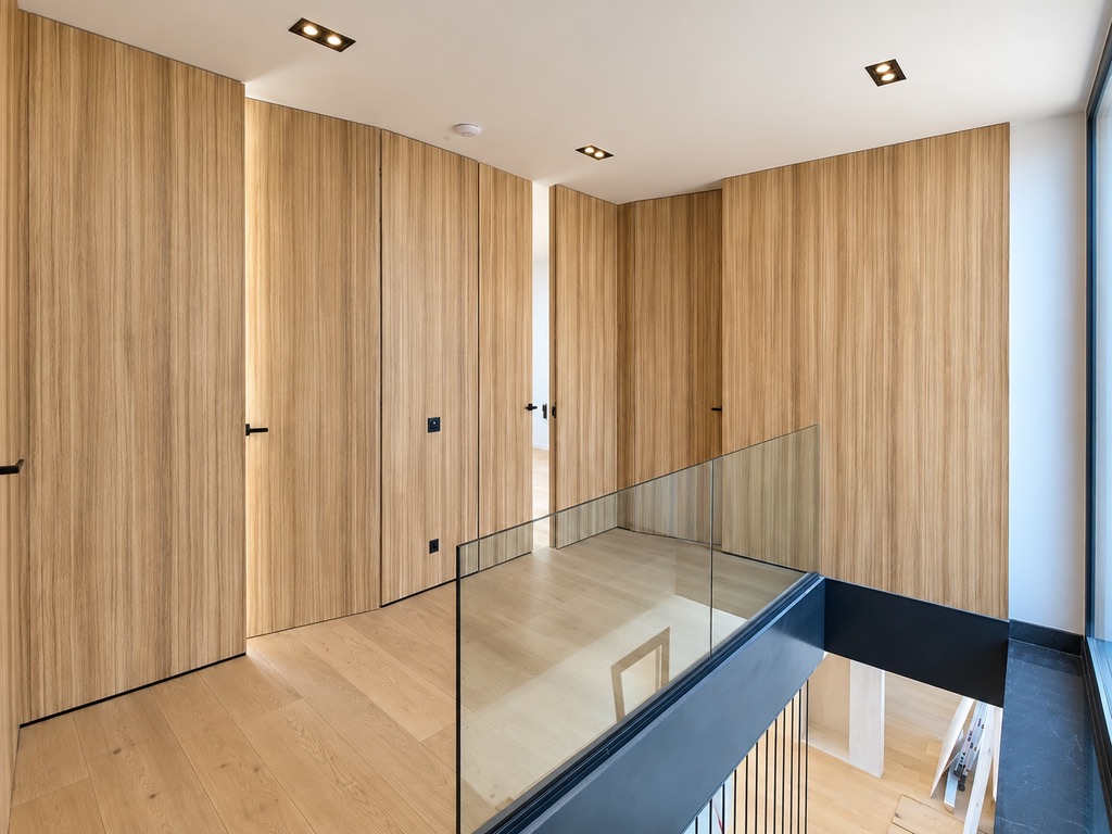 Puertas integradas en un panelado continuo de madera